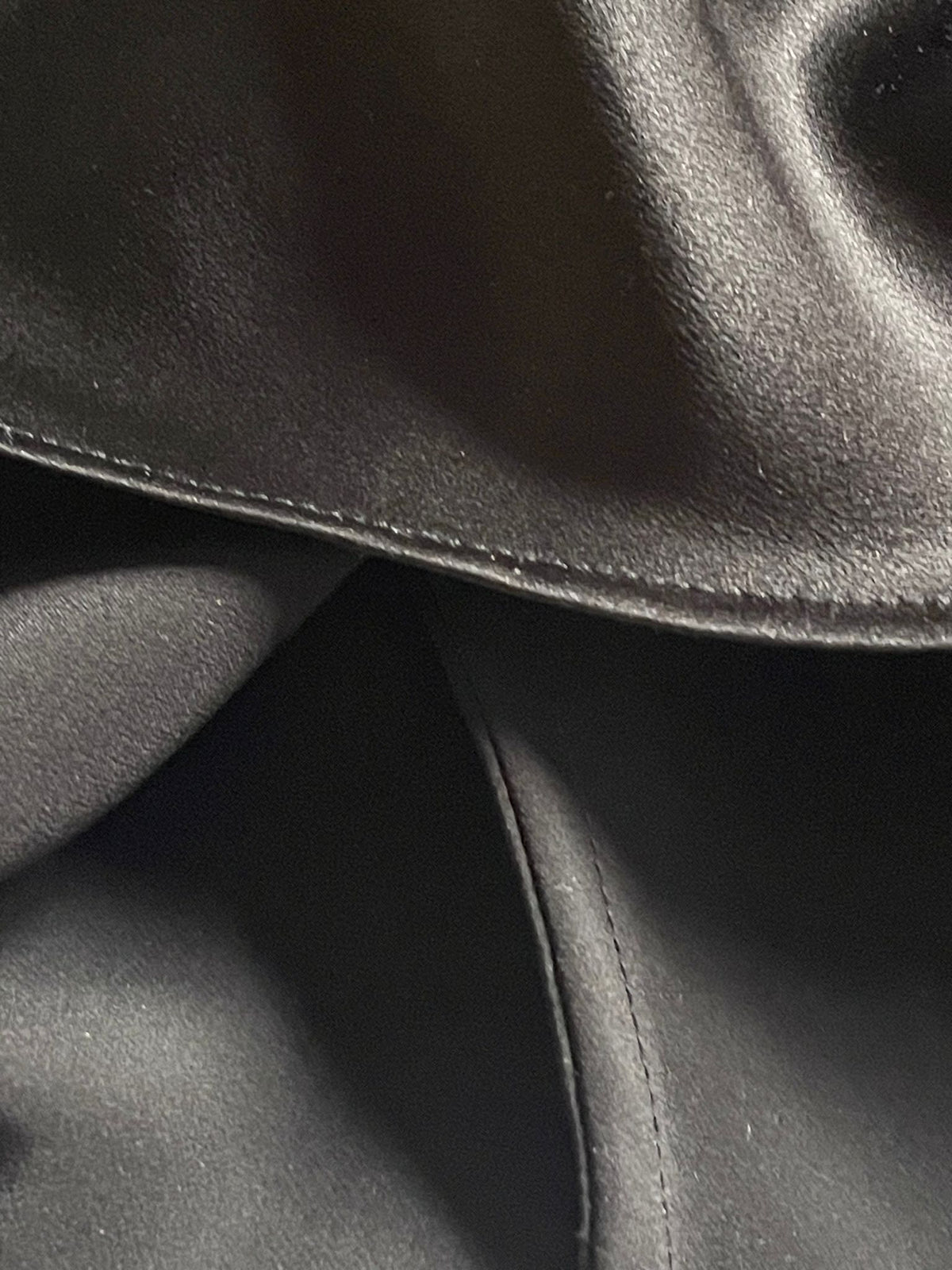 Close up of a french seam on the black bias cut silk slip dress.