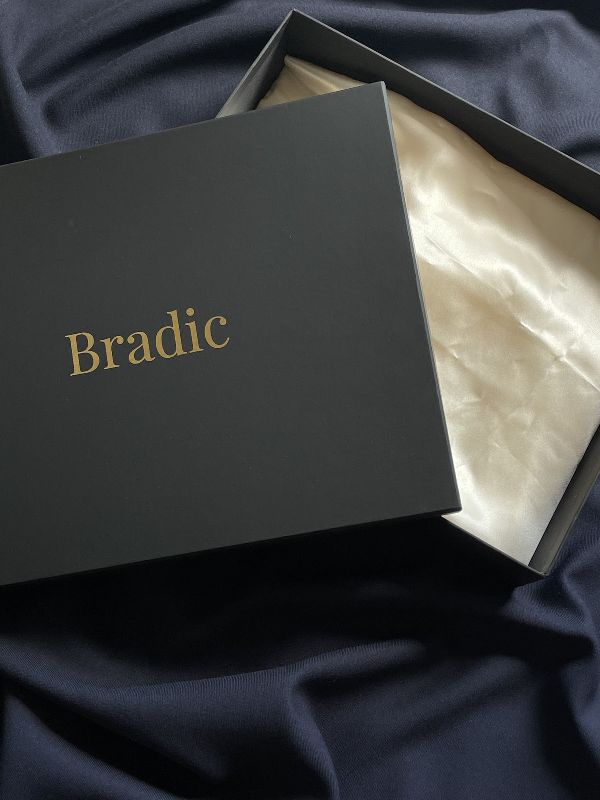 Signature Bradic packaging with silk interior on blue background