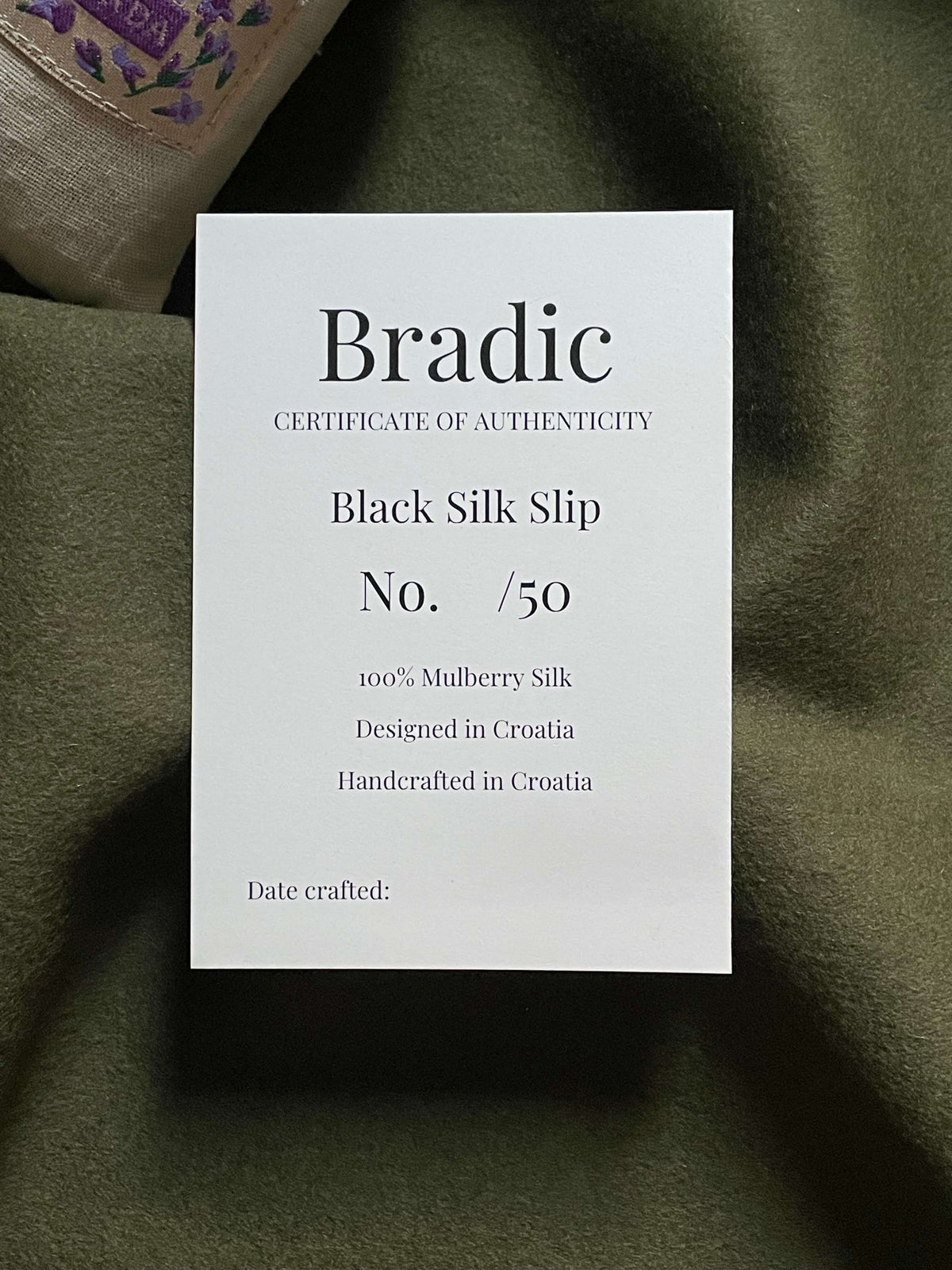 Certificate of authenticity for bias cut silk slip dress by Bradic.