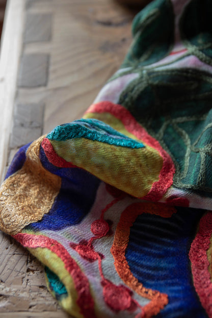 Floral silk-cashmere embroidered fabric on a wooden surface