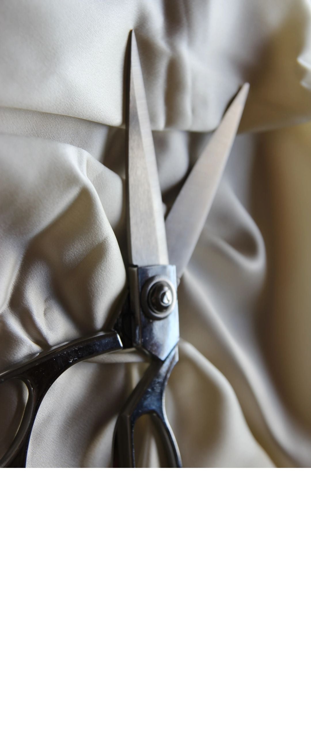 Close-up of a pair of scissors and silk fabric.